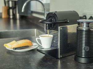a cup of coffee and a sandwich on a counter at Beautiful villa, Den Burg Texel in Westermient
