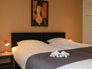two stuffed teddy bears sitting on top of a bed at Beautiful villa, Den Burg Texel in Westermient +14 photos