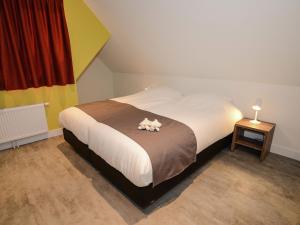 a bedroom with a bed with a stuffed animal on it at Beautiful villa, Den Burg Texel in Westermient