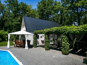 WaterenにあるVilla in Drents-Friese Forest with Poolの白い家(プール、テーブル、椅子付)