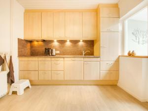 a kitchen with wooden cabinets and a window at Rustic Holiday Home in Kilder with Garden in Kilder