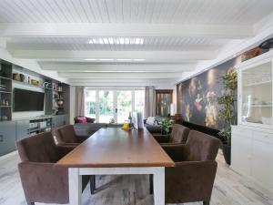WaterenにあるVilla in Drents-Friese Forest with Poolのリビングルーム(テーブル、革張りの椅子付)