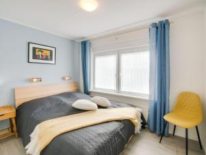 a bedroom with a bed and a chair and a window at Rustic Holiday Home in Kilder with Garden in Kilder