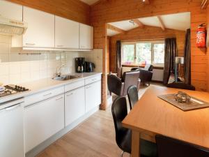 a kitchen and dining room with a table and chairs at Chalet in Overijssel with Spacious Terrace in Ootmarsum