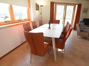 uma sala de jantar com uma mesa branca e cadeiras em Relax in a luxury villa by the dunes em De Cocksdorp