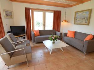 uma sala de estar com dois sofás e uma televisão em Relax in a luxury villa by the dunes em De Cocksdorp