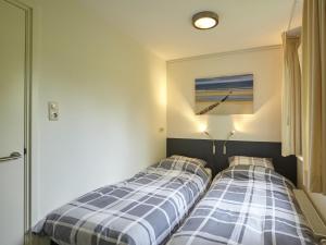 コルトゲーネにあるHoliday home in Kortgene Zealand with Saunaのベッドルーム1室(隣り合わせのベッド2台付)