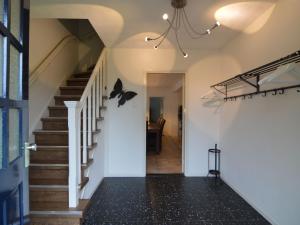 a hallway of a home with a staircase with bats on the wall at Lovely holiday home with lots of privacy in Valkenswaard