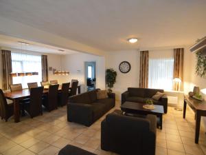 a living room with a couch and a dining room at Lovely holiday home with lots of privacy in Valkenswaard