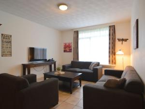a living room with two couches and a table at Lovely holiday home with lots of privacy in Valkenswaard