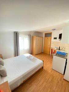 a bedroom with a large bed and a kitchen at Apartments Gajić in Fažana