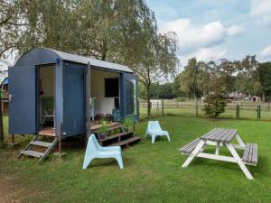 een blauwe schuur met twee stoelen en een picknicktafel bij Majestic, large holiday home near Leende, detached and located between meadows and forests in Leende