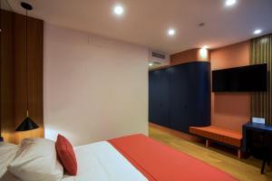 a bedroom with a bed and a flat screen tv at Magnolia Rooms in Naples