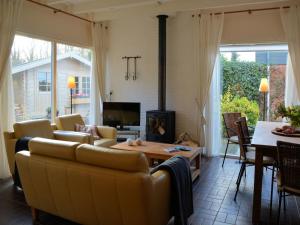uma sala de estar com um sofá e uma mesa em Modern bungalow in South Holland em Noordwijkerhout