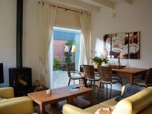 uma sala de estar com uma mesa e uma lareira em Modern bungalow in South Holland em Noordwijkerhout