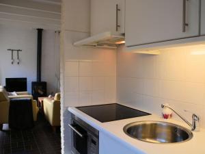 een keuken met een wastafel en een woonkamer bij Modern bungalow in South Holland in Noordwijkerhout
