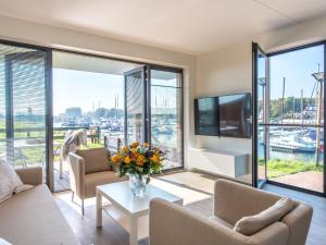 ein Wohnzimmer mit Blick auf den Yachthafen in der Unterkunft New and tasteful apartment with a panoramic view over the marina in Kamperland