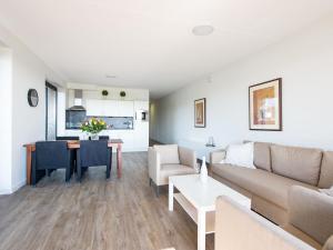 ein Wohnzimmer mit einem Sofa und einem Tisch in der Unterkunft New and tasteful apartment with a panoramic view over the marina in Kamperland