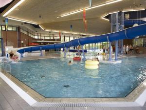 una gran piscina con un tobogán de agua en un edificio en Semi-detached house with a dishwasher, located in Friesland, en Franeker