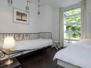 ベルゲンにあるArtist's Holiday Home Near Bergenのベッドルーム1室(ベッド2台、ランプ、窓付)