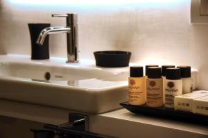 a bathroom with a sink and three bottles of moisturizers at Magnolia Rooms in Naples +9 photos