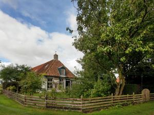 內斯的住宿－Fairytale Cottage in Nes Friesland with garden，前面有围栏的房子