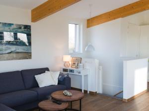 sala de estar con sofá azul y mesa en Elegant Holiday Home in Kamperland next to the Lake, en Kamperland