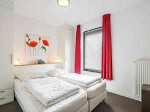 1 dormitorio con 2 camas y una ventana con cortinas rojas en Comfortably vacation home at Slotermeer Lake, en Balk