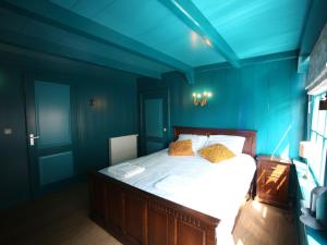 1 dormitorio con paredes azules y 1 cama con almohadas amarillas en Luxury VOC Stay w Views, en Enkhuizen