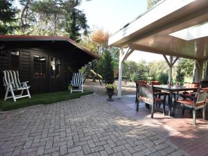 een patio met stoelen, een tafel en een paviljoen bij Cozy Holiday Home in Reutum with Jacuzzi in Weerselo
