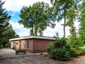 a brick building with trees in the background at Cozy Holiday Home in Reutum with Jacuzzi in Weerselo