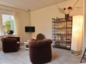 een woonkamer met 2 stoelen en een televisie bij Attractive Apartment in Bergen with Garden in Bergen