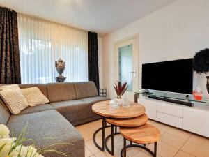 uma sala de estar com um sofá e uma televisão de ecrã plano em Charming holiday home with a covered terrace em Meijel