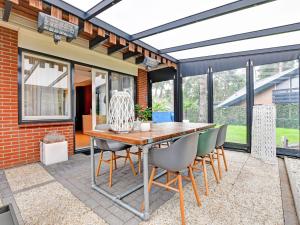 um pátio com uma mesa de madeira e cadeiras em Charming holiday home with a covered terrace em Meijel