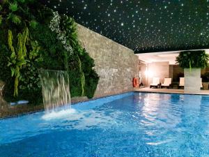 a swimming pool with a waterfall in a hotel at Grand Residence by NewInn in Basaksehir