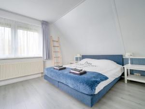 - une chambre avec un lit bleu et blanc et une échelle dans l'établissement Captivating Holiday Home in Zeewolde near Forest, à Zeewolde