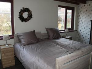 a large bed in a bedroom with two windows at Elegant Holiday Home with Horssen with Terrace in Horssen