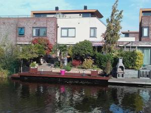 a house sitting on the side of a river at Sunny holiday home in Alkmaar on the water in Alkmaar