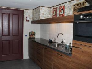 a kitchen with a sink and a microwave at Elegant Holiday Home with Horssen with Terrace in Horssen