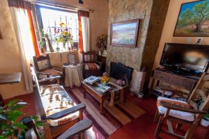 a living room with a television and a table and chairs at Hotel Norte Rupestre in Tilcara