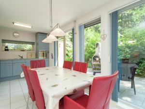 OudemirdumにあるVilla with garden and fireplaceのキッチン、ダイニングルーム(テーブル、赤い椅子付)