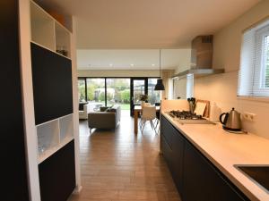 eine Küche mit einer Theke und ein Wohnzimmer in der Unterkunft Bungalow near Veerse Meer with Private Garden in Kamperland + 32 Fotos