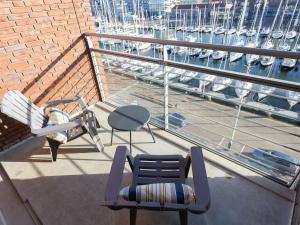 uma varanda com cadeiras e uma mesa e vista para um porto em Luxury apartment fantastic view of the marina in Scheveningen em Scheveningen