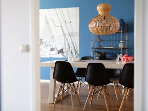 een eetkamer met een witte tafel en zwarte stoelen bij Luxury apartment fantastic view of the marina in Scheveningen in Scheveningen