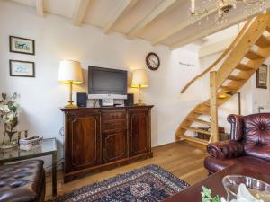 a living room with a television on a wooden cabinet at Sunny holiday home near the sea in Wemeldinge