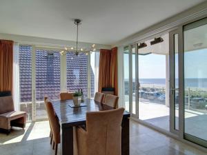 エグモント・アーン・ゼーにあるLuxury apartment with sea view in a residence on the boulevard of Egmondのダイニングルーム(テーブル、椅子付)