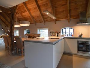 una cocina con una isla blanca en una habitación en Stylish Farmhouse with Private Garden and Sauna, en Nieuwleusen