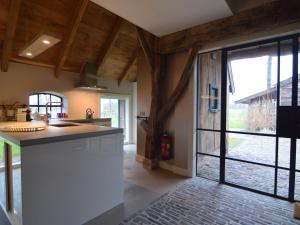 una cocina con una gran puerta corredera de cristal que da a un patio en Stylish Farmhouse with Private Garden and Sauna, en Nieuwleusen