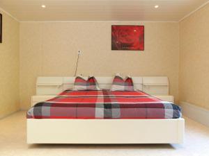 a bedroom with a bed with a plaid blanket at Tranquil Farmhouse near Forest in Ulicoten with Terrace in Ulicoten