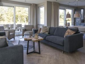 - un salon avec un canapé bleu et une table dans l'établissement Ritzy villa in De Cocksdorp Texel with terrace, à De Cocksdorp